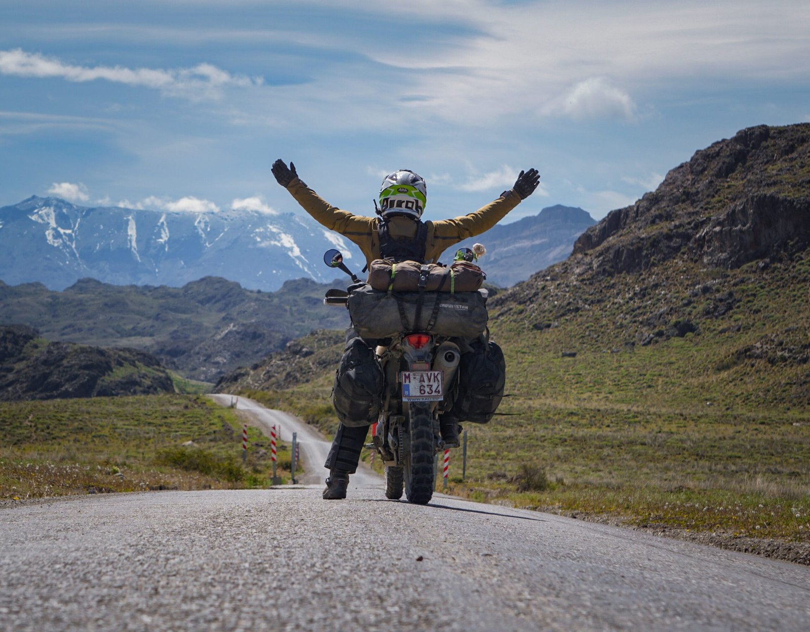 Women on her red motorbike on the gravel road towards Paso Roballos