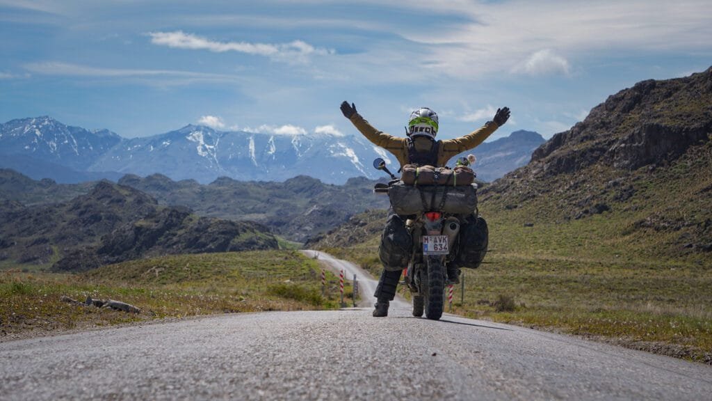 Women on her red motorbike on the gravel road towards Paso Roballos